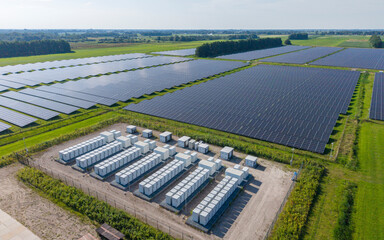 Aerial view of a large-scale solar farm featuring extensive rows of photovoltaic panels and a battery energy storage system in the rural landscape of Wanneperveen, Overijssel, Netherlands. © Ewout Pahud