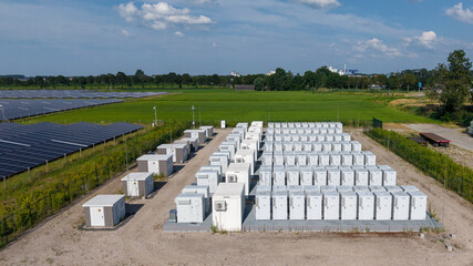 Aerial view of a large-scale solar farm featuring extensive rows of photovoltaic panels and a battery energy storage system in the rural landscape of Wanneperveen, Overijssel, Netherlands. © Ewout Pahud