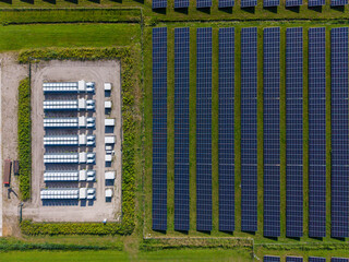 Aerial view of a large-scale solar farm featuring extensive rows of photovoltaic panels and a battery energy storage system in the rural landscape of Wanneperveen, Overijssel, Netherlands. © Ewout Pahud