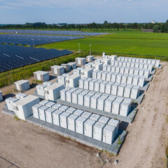Aerial view of a large-scale solar farm featuring extensive rows of photovoltaic panels and a battery energy storage system in the rural landscape of Wanneperveen, Overijssel, Netherlands. © Ewout Pahud