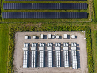 Aerial view of a large-scale solar farm featuring extensive rows of photovoltaic panels and a battery energy storage system in the rural landscape of Wanneperveen, Overijssel, Netherlands. © Ewout Pahud