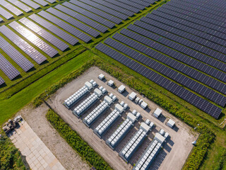 Aerial view of a large-scale solar farm featuring extensive rows of photovoltaic panels and a battery energy storage system in the rural landscape of Wanneperveen, Overijssel, Netherlands. © Ewout Pahud
