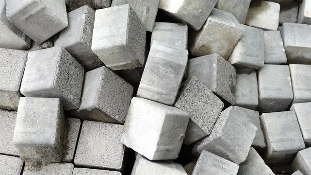 Gray stone paving blocks stacked together representing construction materials, road paving, urban landscaping and infrastructure development