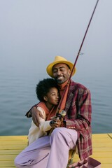 Fototapeta premium Father and child fishing on yellow dock by the lake with fishing rod for family outdoor background and banner design
