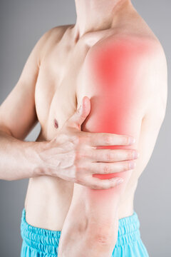 Close up of man holding painful arm and shoulder with red highlighted area. Biceps or triceps muscle rupture, severe sports injury concept