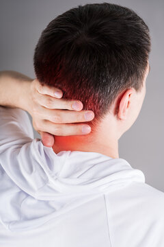 Close up of man holding painful neck and back of head with red highlighted spot, cervicogenic headache or cervical osteochondrosis concept