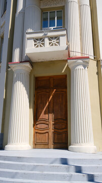 House with a large front door and white trim. Front door with white columns and steps.