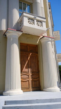 House with a large front door and white trim. Front door with white columns and steps.