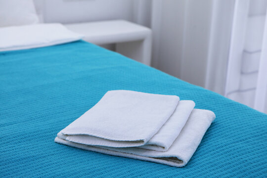 White terry towels are lying on bed. Close-up. Vacation apartment. Leisure and travel concept