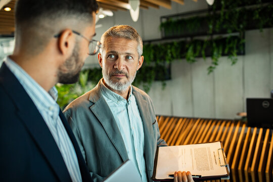 Business colleagues discussing documents in modern office