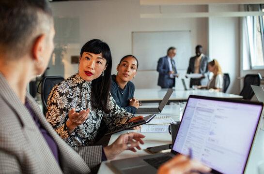 Diverse coworkers discussing project in modern office conference room