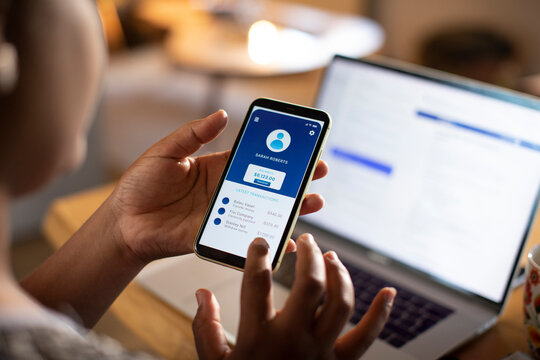 Person using smartphone banking app at home office