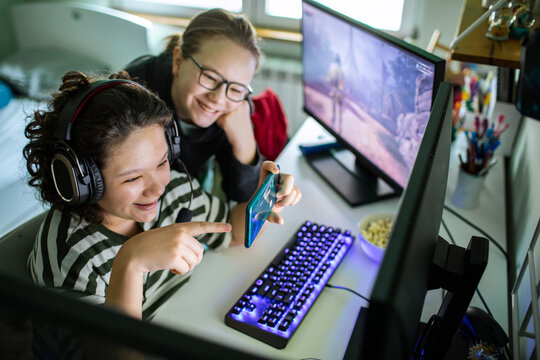 Two friends gaming at home computer desk
