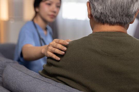 Caring female nurse providing comfort to senior man patient showing empathy and compassion during medical consultation offering emotional support for health condition