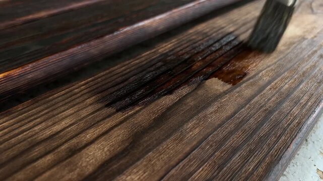 Close-Up of Oiling Charred Pine Wood Surface with Brush