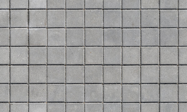 Evenly spaced square concrete pavers form a repeating seamless pattern ideal for urban pavement, flooring and background uses. Neutral gray texture conveys durability, order and modern design
