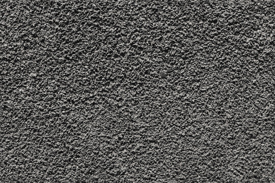 Rough gray asphalt texture showing close-up tarmac detail and uneven surface. Ideal background for road  construction and design projects, seamless patterns and industrial or urban visual uses