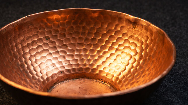 Close-up of a hammered copper bowl with textured surface and warm metallic tones