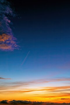 Horizon ablaze with sunset hues, twilight sky transitions from deep blue