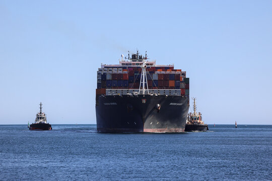 Perth, Western Australia, Australia - July 15 2026: Large container ship entering the Fremantle Inner Harbour on the way to North Quay with assistance of tugboats. Copy space