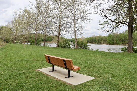 The empty wood park bench near the river.