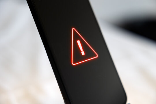 Smart phone problems, system warning sign on screen. Network security, firewall, samrtphone virus, data, privacy, safety, danger, computer crime, hacked mobile phone.