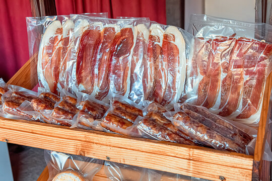 Various cold cuts including ham and salami sausages in vacuum packaging, displaying food preservation and delicatessen products