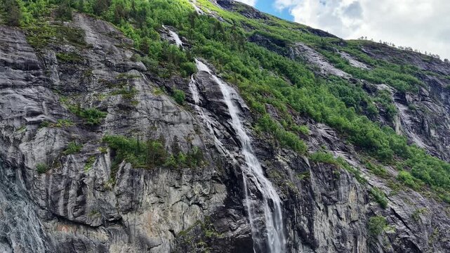Aerial Shot of a Small Waterfall Flowing from Trollstigen Mountains into Rauma River