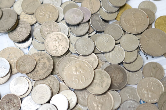 Overhead View of Scattered Malaysian Coins on Financial Statement Document