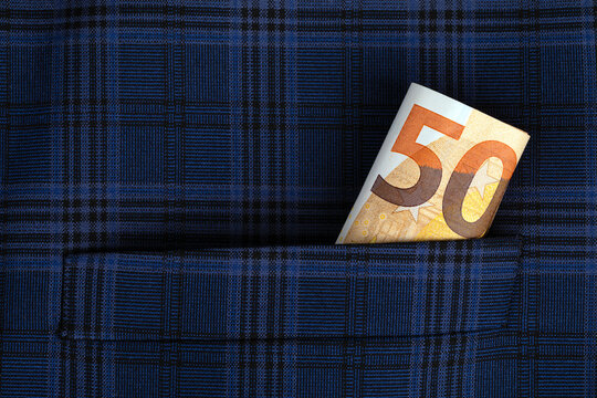 Fifty euro banknote sticking out of a blue plaid pocket, symbolizing savings, finance, or hidden money. Perfect for banking or business concepts.