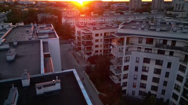 Aerial view of a medium-sized city with numerous densely populated housing estates during sunset.