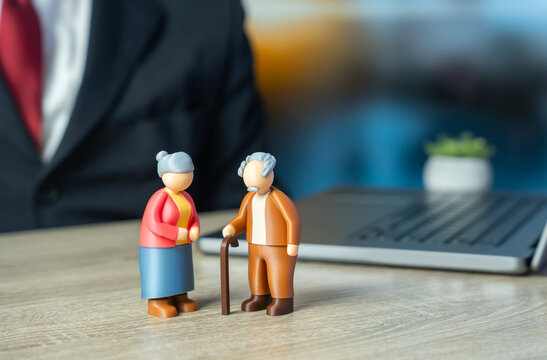 Elderly pensioners grandfather and grandmother standing at the work desk. Pension policy, discussing retirement savings, insurance plans, social security benefits, and financial stability for old age.