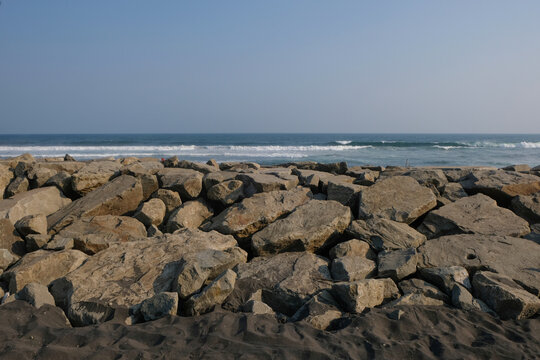 Rock wall barrier for coastal protection against sea waves and erosion. Shoreline defense with natural stone. Suitable for marine infrastructure and resilience concepts