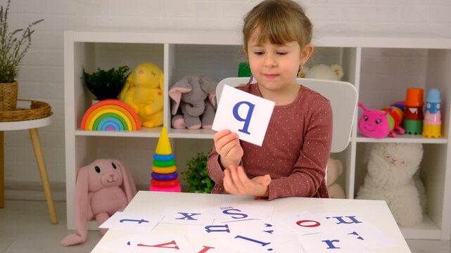 The child learns English letters. Selective focus.