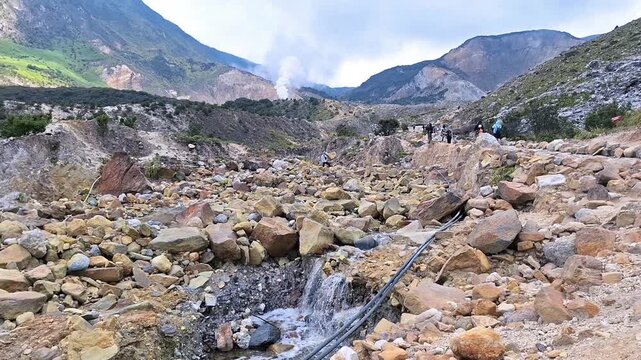 Rocky volcanic landscape with steaming geothermal vents at Mount Papandayan.
