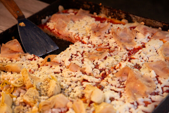 Delicious pizza with ham and artichoke hearts, ready to serve in Ballaro Market in Palermo Sicily