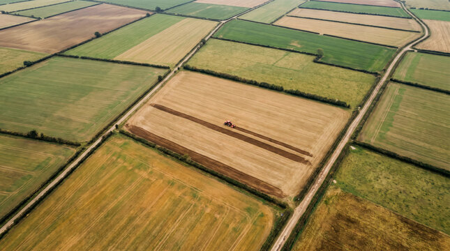 Aerial abstraction of geometric farmland fields with a tractor working one plot