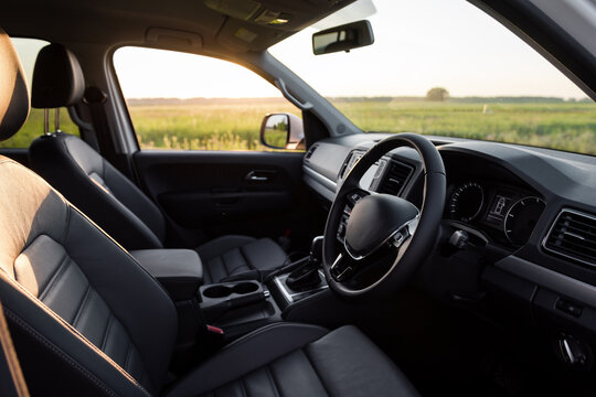 Interior of a truck at sunset. Front row of seats and dashboard of or SUV in a meadow.