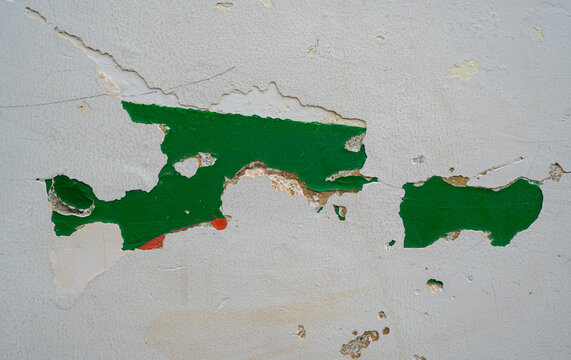 Pared con pintura descascarada y textura envejecida en tonos blanco y verde, fondo de deterioro urbano
