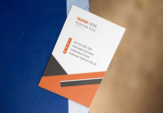 Mockup of A blank business card is placed on a blue and beige surface