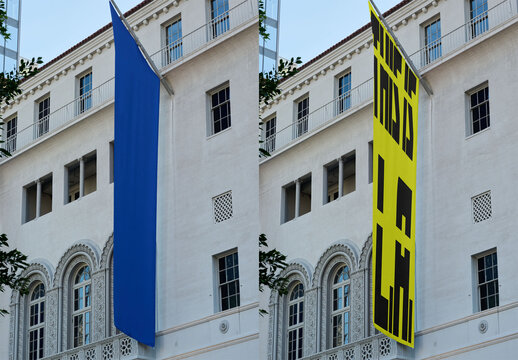 Mockup of blue fly banner hangs on the facade of a building in Los Angeles.