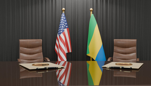 Diplomatic Encounter: The United States and Gabon flags stand tall, flanking empty leather chairs at a polished conference table, setting the stage for high-level international negotiations.
