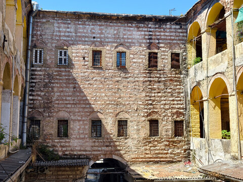 Exploring a historic building with stone walls and arches in a busy market area during daytime