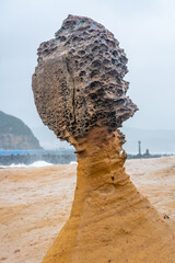 Fototapeta premium Side view of the famous hoodoo stone called Queen's Head in Yehliu geopark in New Taipei Taiwan