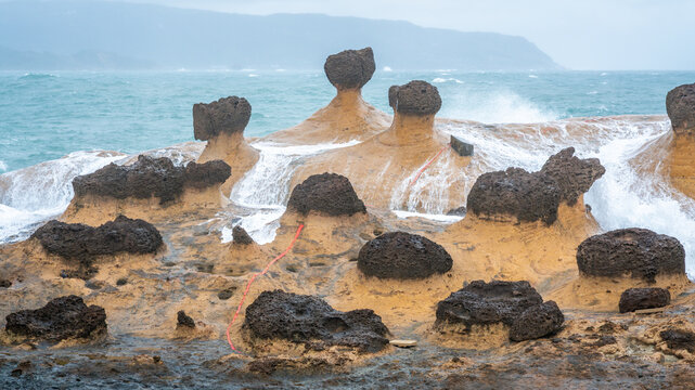 Scenic view of hoodoo stones rock formation with water on rocks in Yehliu geopark in New Taipei Taiwan