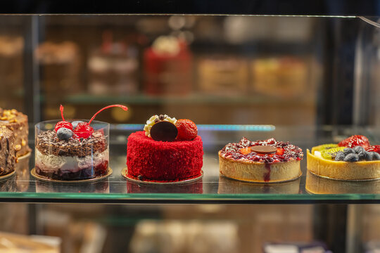 Assortment of delicious artisanal cakes and tarts in a bakery display case.