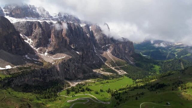 Passo Gardena Dolomites Italy Aerial Drone Orbit Flight Around Sharp Peaks Val Gardena Majestic Alpine Landscape Green Valley Below Epic Mountain Scenery High Altitude Travel Video 4K UHD