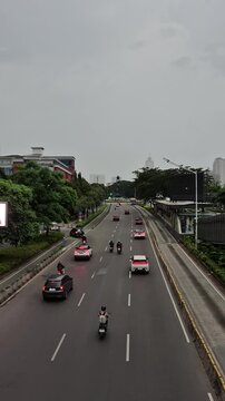 Vertical shot of modern skyscrapers and empty city street at Jenderal Sudirman avenue in the afternoon, view from Bundaran Senayan bridge in Jakarta, Indonesia