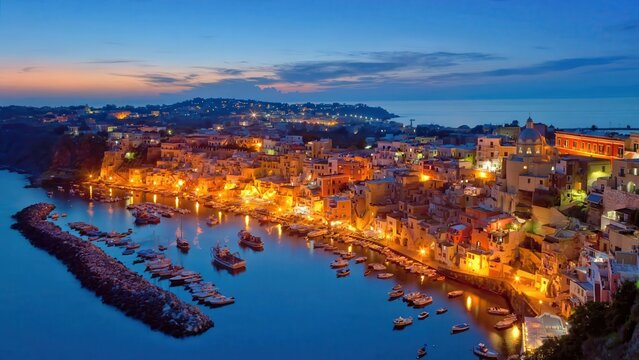 Beautiful panoramic view of the colorful Procida island harbor at twilight in Italy.