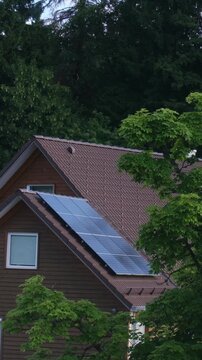 Photovoltaic solar panels generating clean energy on a residential rooftop surrounded by trees, highlighting sustainable living and renewable power technology